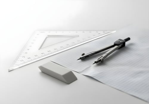 Minimalist geometric arrangement of triangle ruler, compass, eraser, and graph paper on white office desk with ultra-clear detail photo