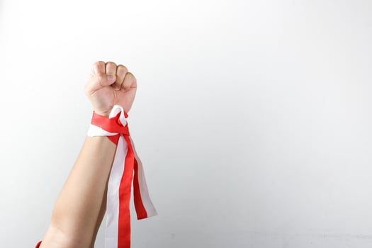 A person holding a red and white ribbon photo