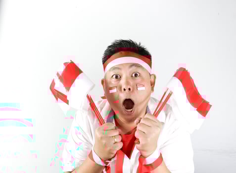 A man with a surprised expression holding two flags photo
