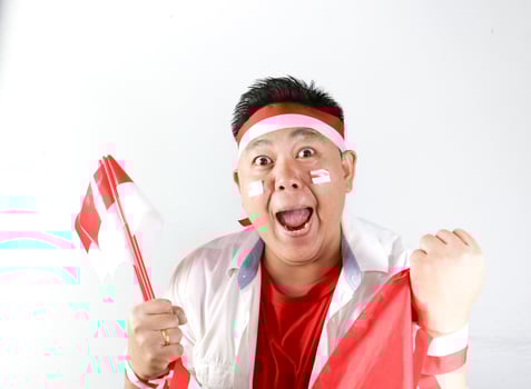 A man with a singapore flag and a face painted red photo