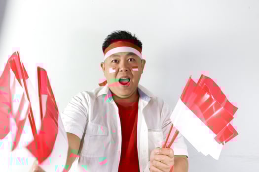 Excited Asian man with indonesian flags on his hand, indepedence day photo