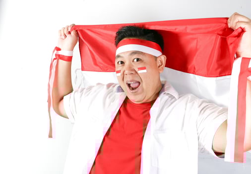 A man holding up a red and white flag photo