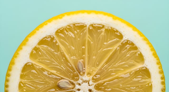 Macro of lemon half showing inner texture and glistening juice, ultra detailed, crisp edges, noise free, natural lighting, pastel mint background, fresh fruit macro photo