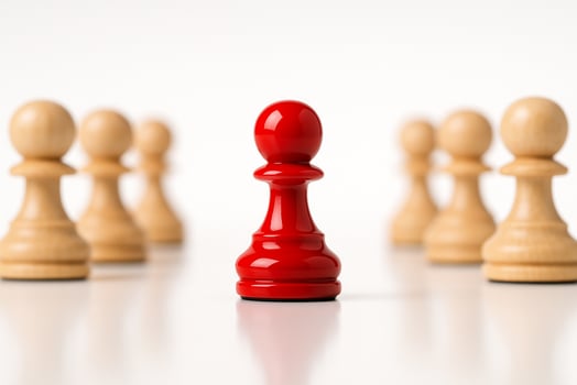 Glossy Red Pawn, glossy red pawn opposite another red pawn among light wood pawns in perfect symmetrical formation. photo