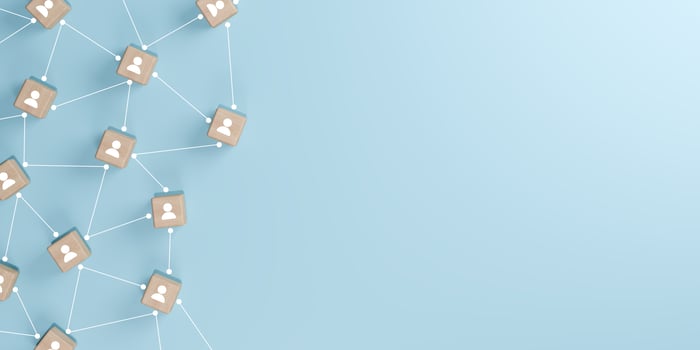 3D render of wooden cubes with people icons connected by white lines on a light blue background with copy space, representing the concept of teamwork, social networking, business connections. photo