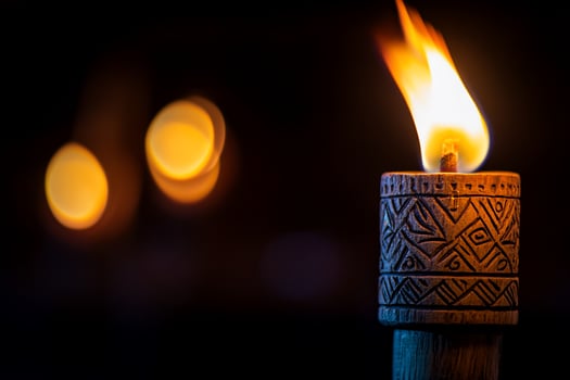 Nighttime tiki torch flames blurred lights tropical event photo