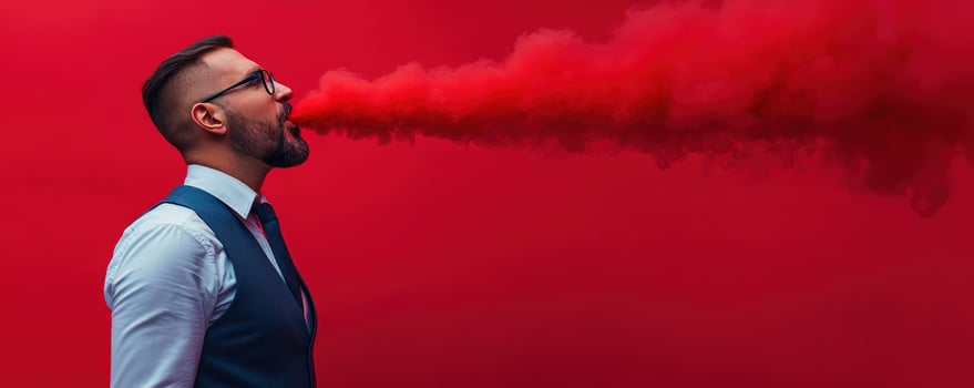 Man exhales red smoke red background studio photo