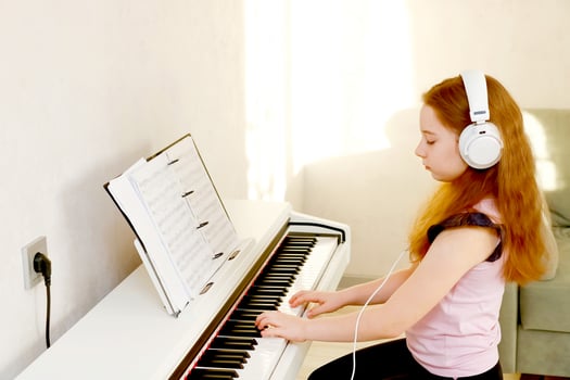 red-haired girl with headphones plays piano photo