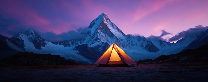 Illuminated tent at mountain sunset photo