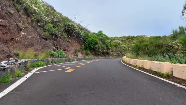 A beautiful and picturesque winding road that is surrounded by lush greenery rocky terrains and scenic views photo