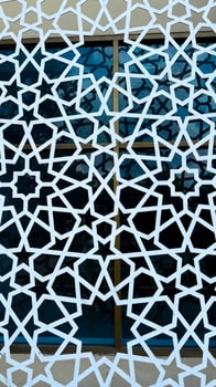 White islamic star pattern overlays blue window frames creating geometric symmetry art photo