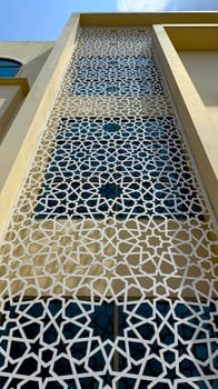Islamic geometry pattern screen adorning a tan building facade creates a captivating high resolution photo