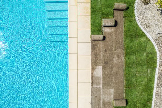 Refreshing Swimming Pool Area With Lounge Spots Beside Grassy Landscape photo