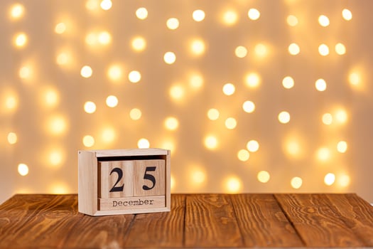 christmas wooden calendar 25 december on wooden background and lights background photo