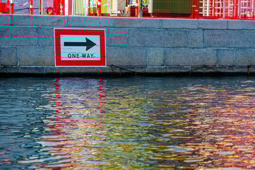 One Way sign at concrete port pathway by the water photo
