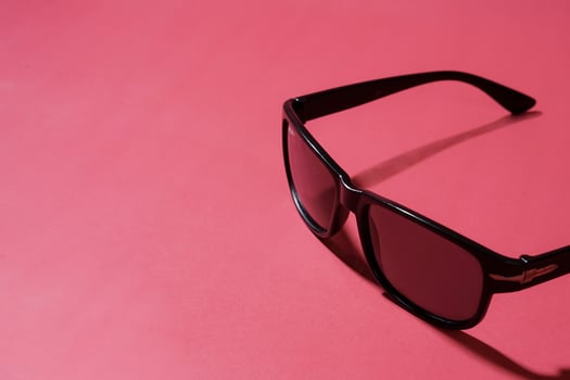 Stylish Black Sunglasses on a Vibrant Pink Background photo