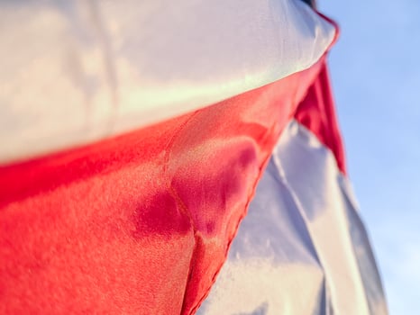 Abstract fabric with soft focus shows white and red colors against a blue sky background. photo