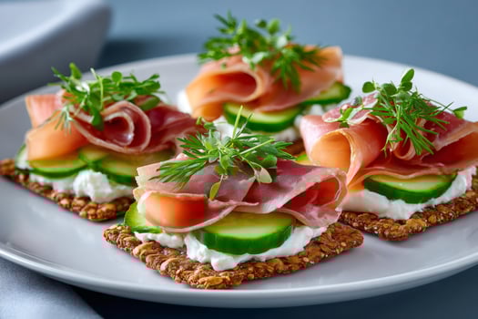 Crispbread c with cream cheese, cucumber and prosciutto garnished with fresh dill photo