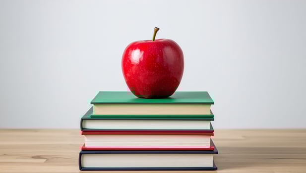 An Apple on a Stack of Colorful Books, a Symbol of Knowledge and Education. photo