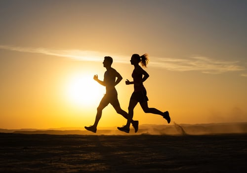 Silhouetted runners against a vibrant sunset, fitness and health concept photo
