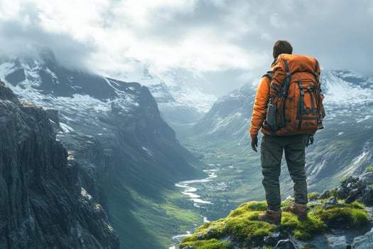 A man with a backpack standing on a mountain top photo