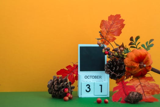 Pine cones and leaves decorate a calendar with the date for Halloween. Space for text. photo