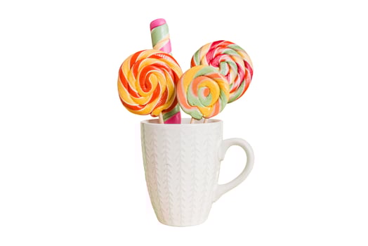 Colorful candies in cup on table on light background background. Large swirled lollipops. Creative concept of a jar full of delicious sweets from the candy store photo