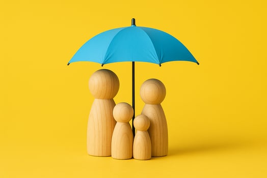 Wooden peg figurines representing a family standing under a blue umbrella on a yellow background symbolizing protection and security photo