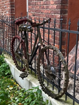 A bicycle is covered in weeds and is leaning against a brick wall. Latvia, Riga 08.10.2023 photo
