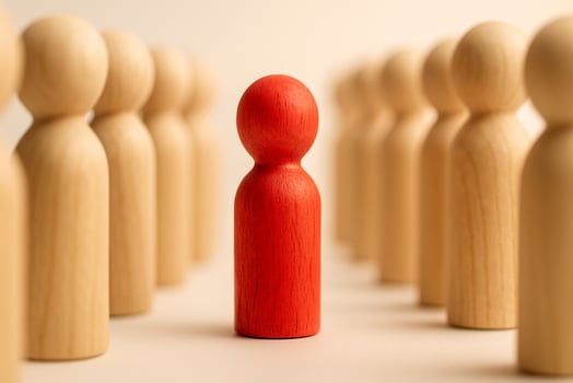A red figurine in front of two lines of natural figurines symbolizing command and organized following. photo