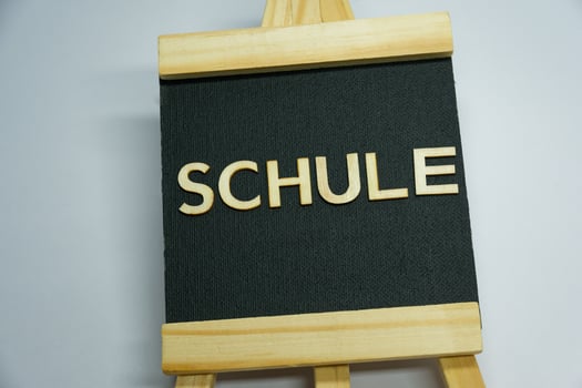 Wooden Word Display Featuring the Term SCHULE on Black Fabric photo