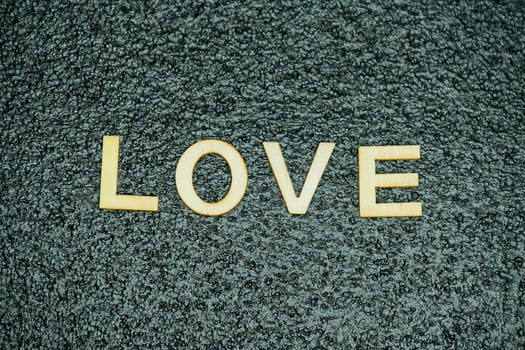 Word love formed by wooden letters on black rubber mat photo