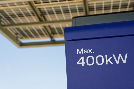 Solar panels with blue energy box marked max 400 kW under sunny sky to charge electric cars photo