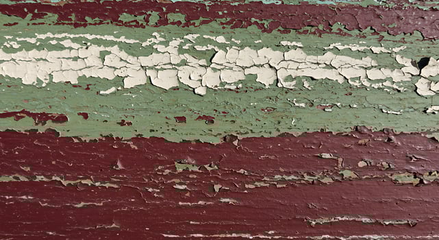 Close-up of Weathered Painted Wood Surface with Cracked Green and Red Paint photo
