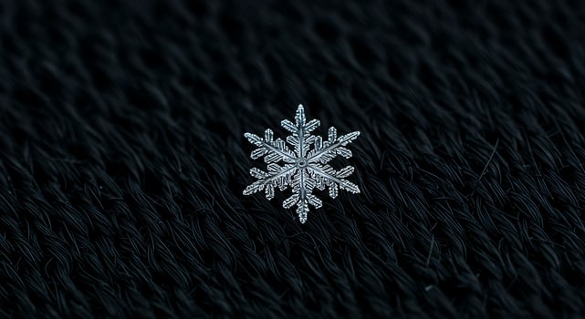 Close Up Silver Snowflake on Black Knitted Fabric Background photo
