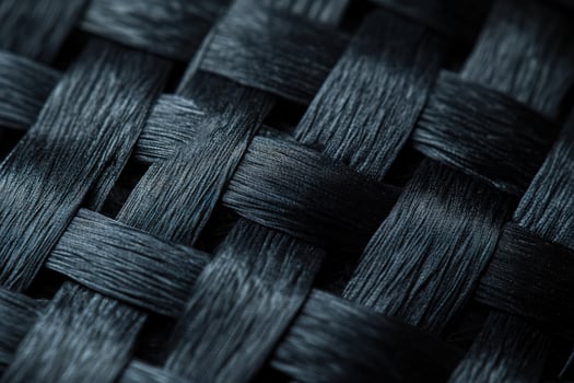Macro shot reveals an abstract woven pattern of dark textured fiber material photo