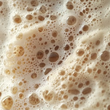 Close up reveals intricate bubbles and foam texture on a light brown beverage photo