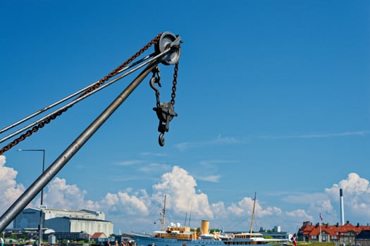 Large crane in the port with ships, buildings, and blue sky view in Copenhagen CPH photo