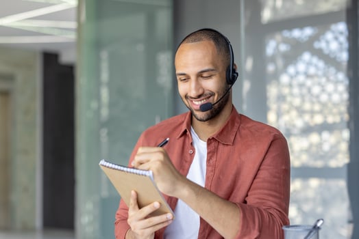 Man taking notes with headset photo