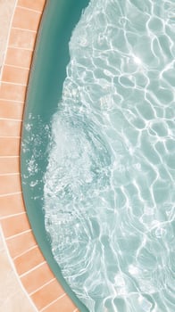 Overhead shot captures sunlit ripples and surface details of a serene, crystalclear swimming pool photo