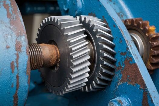 Close up of metallic gears in a blue industrial machine showcasing intricate details. photo
