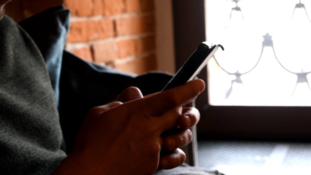 Male hands hold and tap screen of smartphone by fingers photo