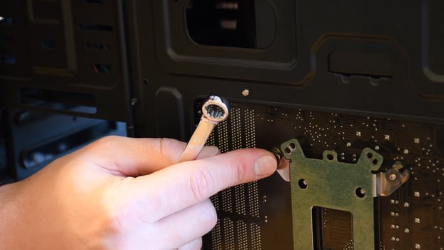 Male hand with small wrench fix nut on bolt at computer motherboard photo