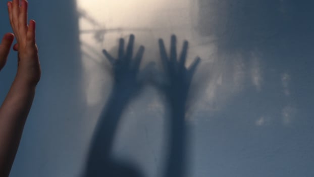 Defocus shadows of kid hands on stucco wall surface with copy space. Halloween concept photo