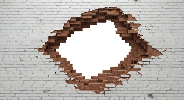 White Brick Wall with Large Irregular Hole in Center Showing Red Bricks photo