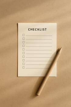 Checklist sheet and pencil on beige paper with sun stripes, hard light minimal workspace photo