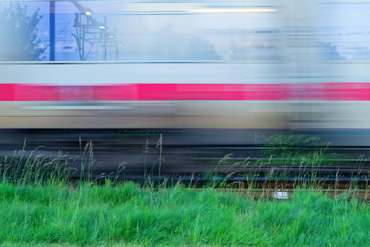 Blurred white Deutsche Bahn train speeding past green grass photo