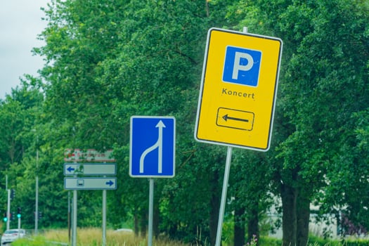 Yellow parking sign with concert arrow and lane merge traffic sign photo