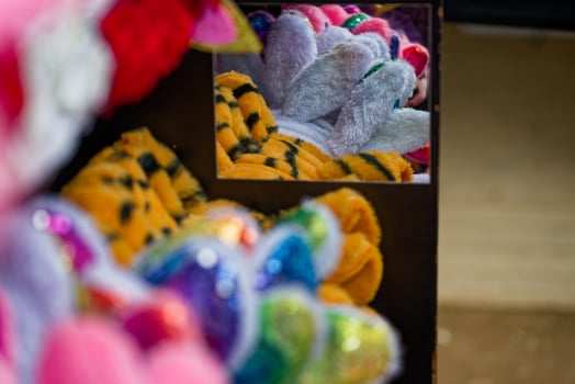 Colorful plush toys with sequins reflected in nearby mirror display photo