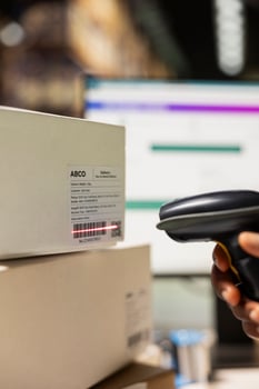 Close up of warehouse clerk registering barcodes for packages, scanning the shipping labels and awb tags on cardboard boxes. Fulfillment center distribution operations for e-commerce. photo
